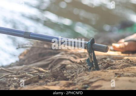 Canne da pesca bloccato nel supporto sul bordo di un fiume, concetto di pesca. Foto Stock