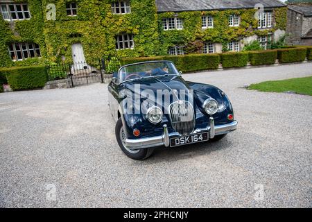 Classic British Jaguar XK150 cabriolet parcheggiato in un villaggio dello Yorkshire in una soleggiata giornata estiva Foto Stock