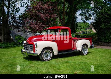 Red 1949 GMC American pick-up camion parcheggiato in erba in una giornata estiva Foto Stock