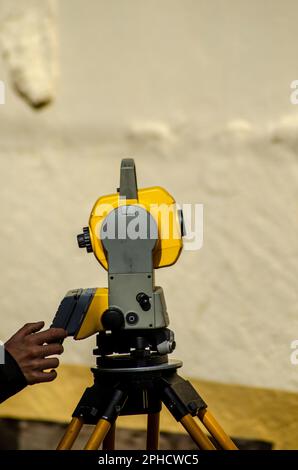 Mano di un tecnico che utilizza una stazione totale per le misurazioni topografiche. Foto Stock