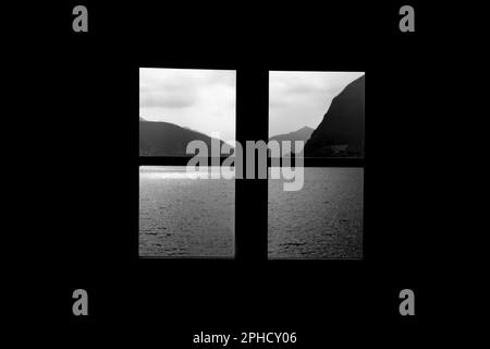 Finestra Vista sul Lago di Lugano con montagna e luce solare a Lugano, Ticino, Svizzera. Foto Stock