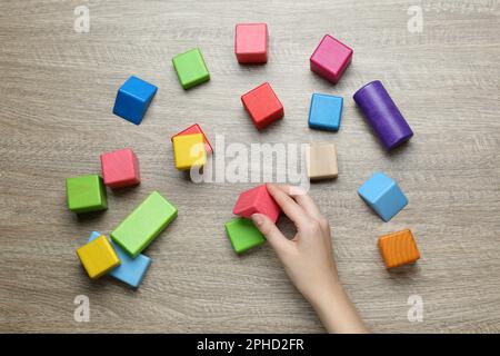 Terapista ABA con blocchi da costruzione colorati al tavolo di legno, vista dall'alto Foto Stock