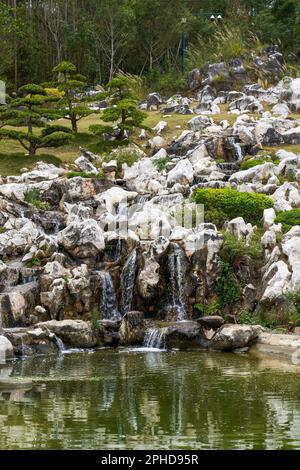 Rockery e stagno in un bel giardino Foto Stock