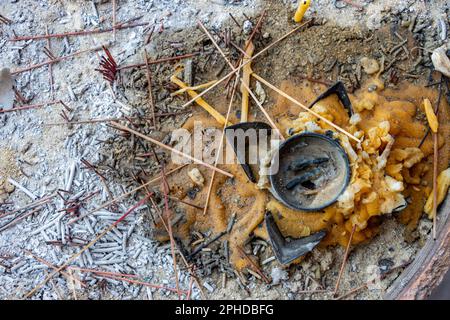 Candele spente e bastoncini di incenso in un vaso in un tempio buddista Foto Stock