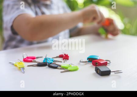 Il bambino lavora con materiale Montessori con serrature colorate. Raccoglie i tasti. Sviluppa le abilità motorie fini. Foto Stock