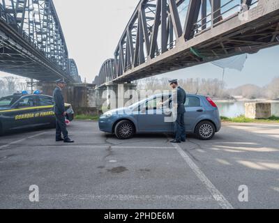 Cremona, Italia - Febbraio 2023 due poliziotti fiscali in servizio presso il ponte sul fiume po al confine tra Lombardia ed Emilia Romagna Foto Stock