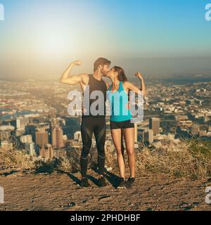 Diventa una coppia di alimentazione di workout. una giovane coppia flexing i loro muscoli mentre fuori per un workout. Foto Stock