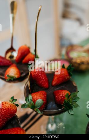 Una gamma colorata di dessert con torte al cioccolato, fragole e frutti di bosco vari Foto Stock