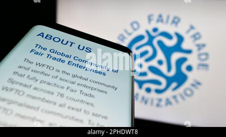 Telefono cellulare con sito web della World Fair Trade Organization (WFTO) sullo schermo davanti al logo. Messa a fuoco in alto a sinistra del display del telefono. Foto Stock