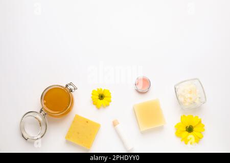 Composizione a posa piatta con cosmetici in cera d'api su fondo bianco. Spazio per il testo Foto Stock