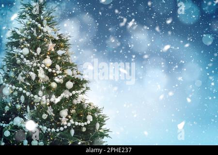 Albero di Natale splendidamente decorato su sfondo azzurro, spazio per il testo. Effetto bokeh Foto Stock