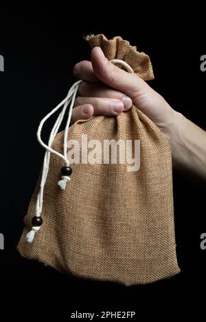 Borsa di lino per il trasporto umano con lacci a mano su fondo nero Foto Stock