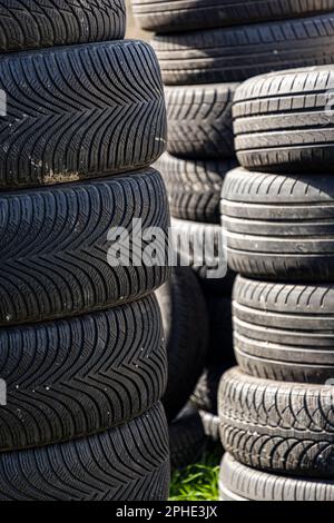 Un mucchio di pneumatici auto nel cortile di casa in una giornata di sole Foto Stock