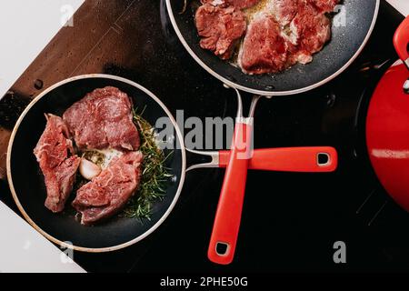 Un primo piano di due padelle di metallo farcite con carne cotta, pronte per essere servite Foto Stock