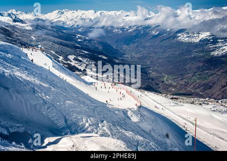 La pista di sci Alps France, che guarda verso le alte montagne delle Alpi giù nelle piste di sci della valle in primo piano Foto Stock