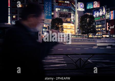 Una guardia stradale si trova sulla strada vicino a una fermata dell'autobus vicino a Shibuya Crossing a Tokyo, Giappone. Foto Stock