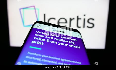 Telefono cellulare con il sito web della società di software US CLM Icertis Inc. Sullo schermo di fronte al logo aziendale. Messa a fuoco in alto a sinistra del display del telefono. Foto Stock