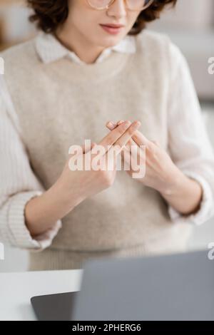 Vista parziale dell'insegnante che mostra l'alfabeto britannico a due mani che significa lettera f durante la lezione online, immagine stock Foto Stock