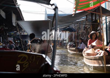 NNessun viaggio in Thailandia dovrebbe perdere il mercato galleggiante di Damnoen. I barcaioli esperti vi porteranno attraverso i canali fiancheggiati da stalle e barche che vendono cibo Foto Stock