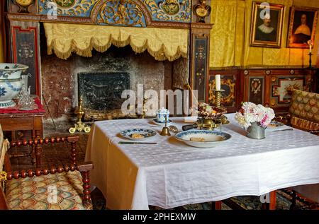 camera da letto zona pranzo, grande camino ornato, tavolo, 2 sedie, piatti, camera, arazzo color oro, antiquariato, Chateau Courmatin; castello del 17th ° secolo; BU Foto Stock