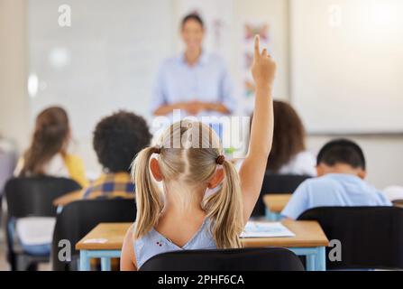 Istruzione, schiena e un bambino che si alza di mano in classe per una domanda, risposta o voto a scuola. Insegnare, accademico e uno studente che chiede un insegnante Foto Stock