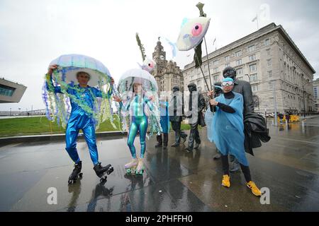 Gli artisti vestiti come meduse su pattini a rotelle pattinano intorno alla statua dei Beatles al lancio dell'Eurovision EuroFestival alla British Music Experience di Liverpool. Il festival di due settimane, che consisterà in 25 commissioni - 19 delle quali sono collaborazioni tra artisti britannici e ucraini - prenderà il controllo della città in testa fino al Concorso di canzoni Eurovision mentre i fan di tutto il mondo scenderanno a Liverpool. Data immagine: Martedì 28 marzo 2023. Foto Stock