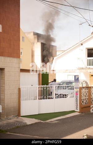 Cangas, Pontevedra, Spagna. marzo, 28th 2023. Facciata posteriore dell'edificio in fiamme fumando da una finestra. Credit: Xan Gasalla /Alamy Live News. Foto Stock