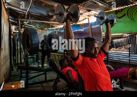 Nairobi, Kenya. 22nd Feb, 2023. La gente che si forma in palestra costruita all'interno di una baracca di Kibera slum. Kibera è la più grande baraccopoli dell'Africa e una delle più grandi del mondo. Ospita una popolazione stimata di 1 milioni di persone che vivono in una situazione di estrema povertà. La maggior parte delle persone non ha accesso ai servizi di base e alle cure mediche: Solo il 20% circa di Kibera ha elettricità, e l’acqua che raggiunge le sue stalle non è pulita e causa tifo e colera. Nella maggior parte di Kibera non ci sono servizi igienici. I tassi di disoccupazione sono elevati e la maggior parte delle persone non può permettersi l'istruzione per loro Foto Stock