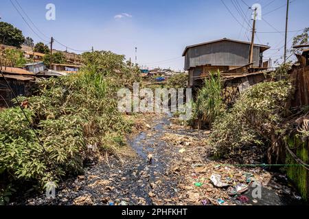 Nairobi, Kenya. 22nd Feb, 2023. Vista di un fiume inquinato che passa attraverso lo slum di Kibera, Nairobi, Kenya. Kibera è la più grande baraccopoli dell'Africa e una delle più grandi del mondo. Ospita una popolazione stimata di 1 milioni di persone che vivono in una situazione di estrema povertà. La maggior parte delle persone non ha accesso ai servizi di base e alle cure mediche: Solo il 20% circa di Kibera ha elettricità, e l’acqua che raggiunge le sue stalle non è pulita e causa tifo e colera. Nella maggior parte di Kibera non ci sono servizi igienici. I tassi di disoccupazione sono elevati e la maggior parte delle persone non può permettersi l'istruzione Foto Stock