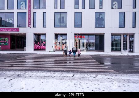 Sandnes, Norvegia, 11 2023 marzo, Famiglia o persone con bambini piccoli che attraversa la strada su Un pedone che attraversa con le spalle alla macchina fotografica Foto Stock