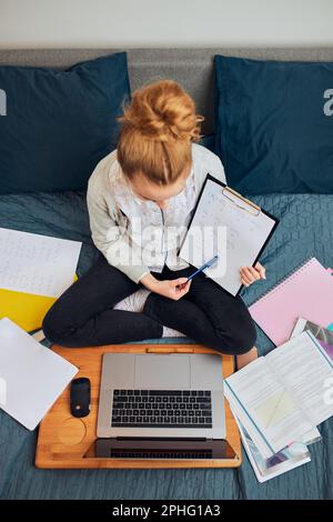 Giovane studentessa che ha classi, imparare online, guardare la lezione da remoto, ascoltare il professore, parlare con i compagni di classe in videochiamata da casa Foto Stock