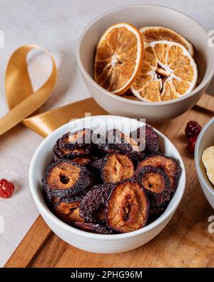 Un primo piano di una varietà di frutta dolce essiccata sistemata in ciotole Foto Stock