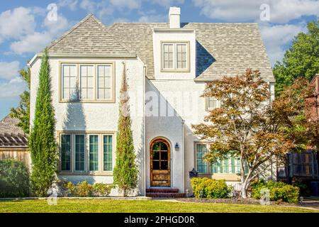 Maestosa casa in stucco a tre piani di colore chiaro con porta ad arco ed eleganti finestre che incorniciano alberi Foto Stock