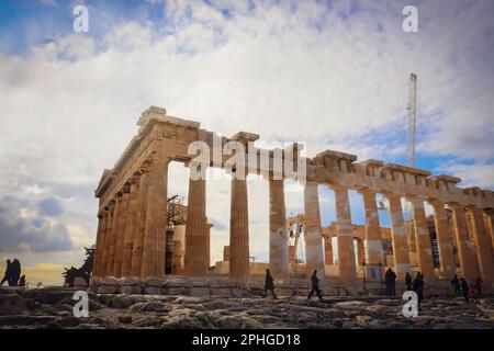 Turisti intorno al Partenone sull'Acropoli di Atene Grecia - edificio in fase di ricostruzione con gru e altri macchinari Foto Stock