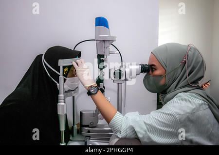 BOGOR, INDONESIA - 27 marzo 2023: Un residente effettua un test oculare utilizzando un'apparecchiatura di test oculistico presso la clinica oculistica Ainun Cahaya Medika, Bogor Regency Foto Stock