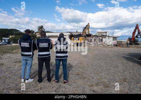 Corigliano Rossano, Italia. 28th Mar, 2023. I bulldozer demoliscono il lido delle Sirene a Corigliano Rossano a seguito di un'ordinanza del comune. Questa struttura era illegale e sulla spiaggia, su terreni di proprietà statale. Era stata abbandonata e fatiscente per molti anni ed è stata considerata un eco-mostro in concreto. In passato era una discoteca della 'Ndrangheta e per anni gestita dalla mafia. Credit: Independent Photo Agency/Alamy Live News Foto Stock
