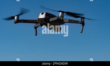 Un mini drone volante che registra video e foto nel cielo blu Foto Stock