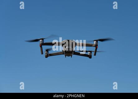 Un mini drone volante che registra video e foto nel cielo blu Foto Stock