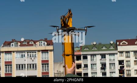 Un mini drone volante che registra video e foto nel cielo blu Foto Stock