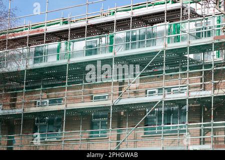 impalcature e reti di sicurezza in cantiere costruzione di nuovi edifici sociali blocco strandtown, belfast orientale, irlanda del nord, regno unito Foto Stock