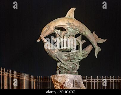 La statua dei due delfini a Rethymnon, Creta, Grecia, (zona Marina) è illuminata di notte. Foto Stock