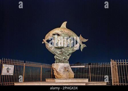 La statua dei due delfini a Rethymnon, Creta, Grecia, (zona Marina) è illuminata di notte. Foto Stock