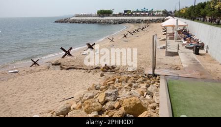 Odessa, Ucraina -2022: Barriere militari metalliche, ricci anticarro sulla spiaggia della città di mare. I vacanzieri si abbronzano accanto ai ricci anticarro in ferro. Recinzioni f Foto Stock