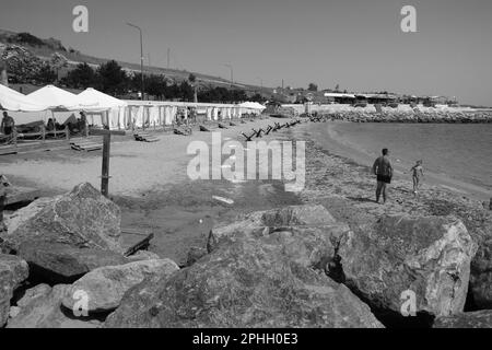 Odessa, Ucraina -2022: Barriere militari metalliche, ricci anticarro sulla spiaggia della città di mare. I vacanzieri si abbronzano accanto ai ricci anticarro in ferro. Recinzioni f Foto Stock