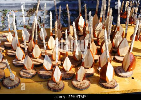 Baglama in miniatura e saz venduti come souvenir in una giornata di sole all'aperto. Baglama è un tipico strumento musicale turco suonato spesso nella cultura turca. Foto Stock