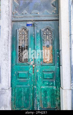 Europa, Portogallo, Lisbona. Vecchia porta verde chiusa con una catena e un lucchetto. Foto Stock
