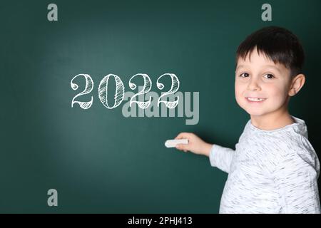 Ritorno a scuola 2022. Bambino carino vicino alla lavagna Foto Stock