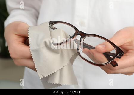 Donna pulizia occhiali con panno in microfibra Foto stock - Alamy