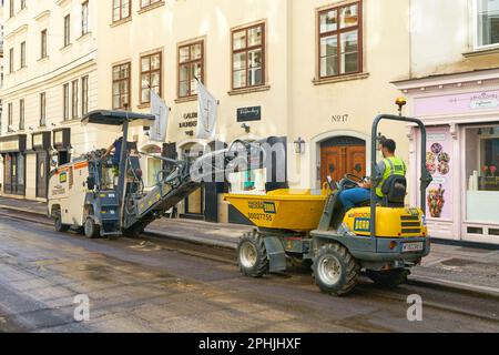 Lavoratori nel centro di Vienna nella Seilergasse durante i lavori di fresatura per rinnovare l'asfalto di una strada Foto Stock