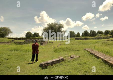 Un uomo cammina attraverso la prateria nel mezzo del Surosowan Palace, un patrimonio culturale del periodo Sultanato di Banten situato in un'area ora chiamata Banten lama (Old Banten) a Serang, Banten, Indonesia, in questa foto scattata nel 2010. "La sostenibilità del patrimonio culturale è fortemente legata all'effettiva partecipazione delle comunità locali alla conservazione e alla gestione di queste risorse", secondo un team di scienziati guidati da Sunday Oladipo Oladeji nel loro articolo di ricerca pubblicato su Sage Journals il 28 ottobre 2022. L'area di Banten lama (Old Banten) era una parte... Foto Stock